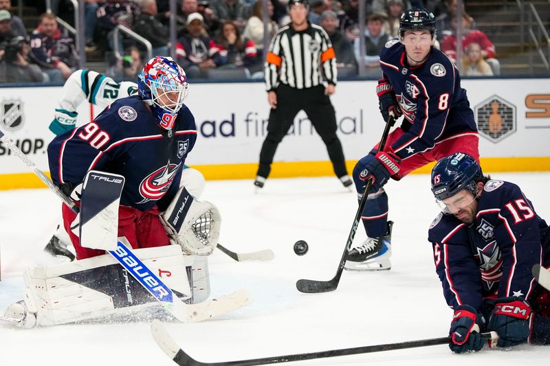 Columbus Blue Jackets defenseman Dante Fabbro (15) and defenseman Zach Werenski (8) attempt to block a shot near goaltender Elvis Merzlikins (90) in the second period of the NHL game at Nationwide Arena on Saturday, March 28, 2026 in Columbus, Ohio.