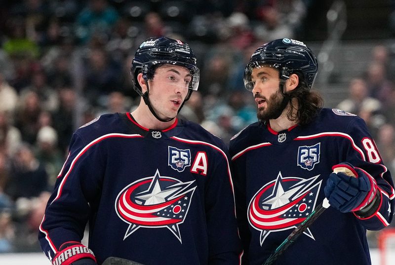Blue Jackets defenseman Zach Werenskileft(8) chats with right wing Kirill Marchenko during a game against the Sharks on March 28.