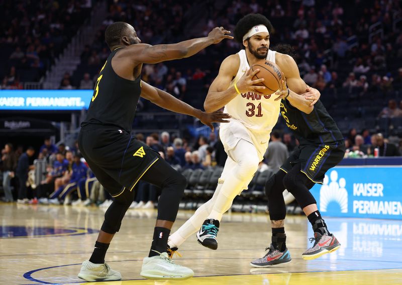 Apr 2, 2026; San Francisco, California, USA; Cleveland Cavaliers center Jarrett Allen (31) drives in between Golden State Warriors forward Draymond Green (23) and forward Gui Santos (15) during the third quarter at Chase Center. Mandatory Credit: Kelley L Cox-Imagn Images