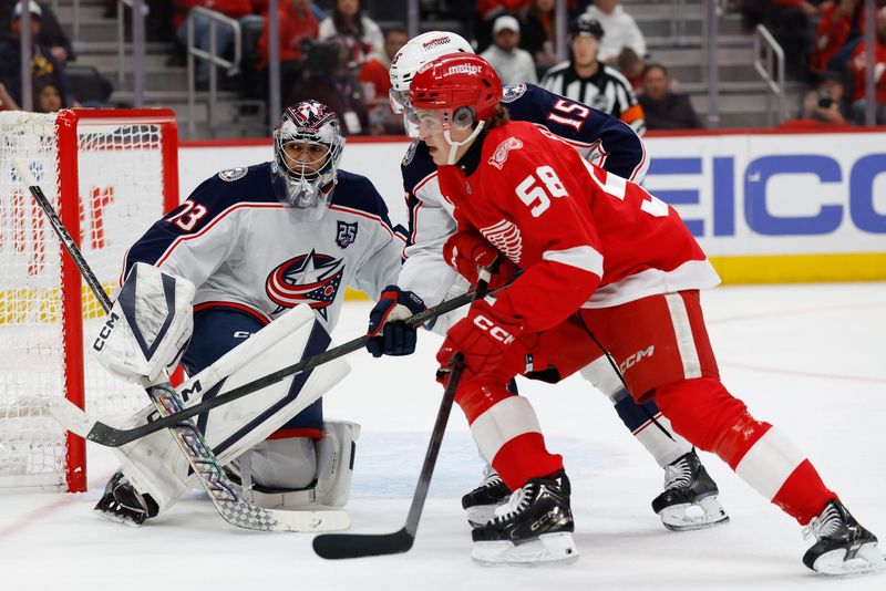 Apr 7, 2026; Detroit, Michigan, USA; Detroit Red Wings center Emmitt Finnie (58) skates against Columbus Blue Jackets defenseman Dante Fabbro (15) in front of goaltender Jet Greaves (73) in the second period at Little Caesars Arena. Mandatory Credit: Rick Osentoski-Imagn Images