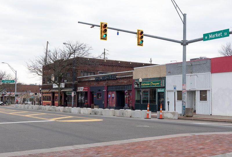 Newly placed barriers limit street parking along a stretch of West Market Street in the heart of the Highland Square neighborhood April 10 in Akron.