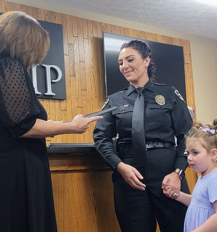 Perry Police Department Detective Danielle Paciorek receives a certificate honoring her 2025 Community Police Officer of the Year award from Trustee Lisa Nelligan, left, on April 14. Also pictured is Paciorek's daughter, Madison, right.