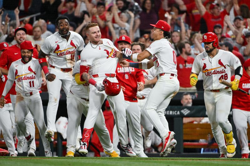 Cardinals center fielder Nathan Church is mobbed by teammates after hitting a walk-off sacrifice fly against the Cleveland Guardians in the 10th inning, April 14, 2026, in St. Louis.