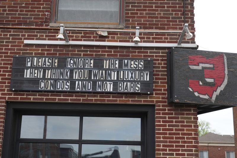 A farewell sign reads “Please ignore the mess..they think you want luxury condos and not bars” as excavators from Loewendick Demolition Contractors tear into The Little Bar along North High Street in the Ohio State University campus area on April 14, 2026. This sign was on the Bar Threes Above High. The demolition of the Little Bar marks the end of a longtime student gathering spot. The bar opened in 2006 and closed for good on March 29, 2026, after nearly 20 years in business, to make way for a new student housing development.