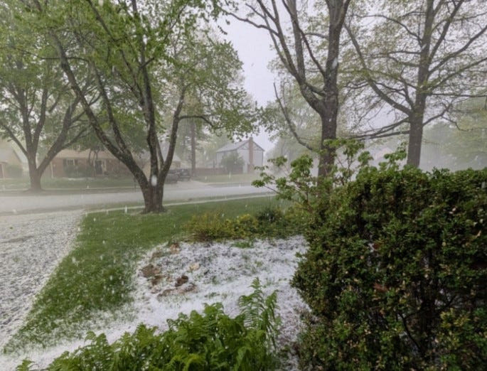 Hail coats a yard on Columbus' Northwest Side on April 22, 2026, as a thunderstorm moves through the area.