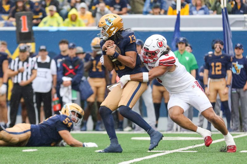 Sep 27, 2025; Morgantown, West Virginia, USA; Utah Utes defensive end Logan Fano (0) sacks West Virginia Mountaineers quarterback Jaylen Henderson (13) during the first quarter at Milan Puskar Stadium. Mandatory Credit: Ben Queen-Imagn Images