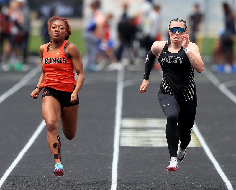 Perry's Emerson Karrenbauer, right, and Hoover's Savannah Tindell finished first and second, respectively, in the girls 100 meters at the 2026 Stark County Track and Field Championships, Saturday, April 25, 2026, at Perry High School.