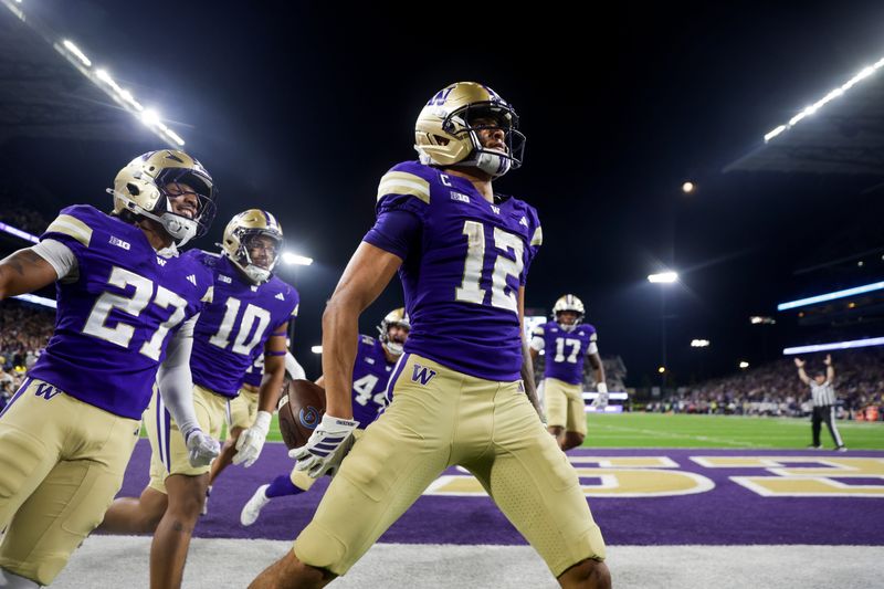 Sep 6, 2025; Seattle, Washington, USA; Washington Huskies wide receiver Denzel Boston (12) celebrates after returning a punt for a touchdown against the UC Davis Aggies during the second quarter at Husky Stadium. Washington Huskies safety Vincent Holmes (27) and linebacker Xe'ree Alexander (10) follow behind Boston. Mandatory Credit: Joe Nicholson-Imagn Images