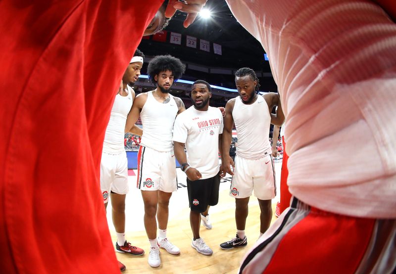 Nov 10, 2023; Columbus, Ohio, USA; (from left) Ohio State Buckeyes guard Roddy Gayle Jr. (left) and guard Taison Chatman (middle left) and coach Quadrian Banks (middle right) and guard Bruce Thornton (right) huddle before the game against the Texas A&M Aggies at Value City Arena.
