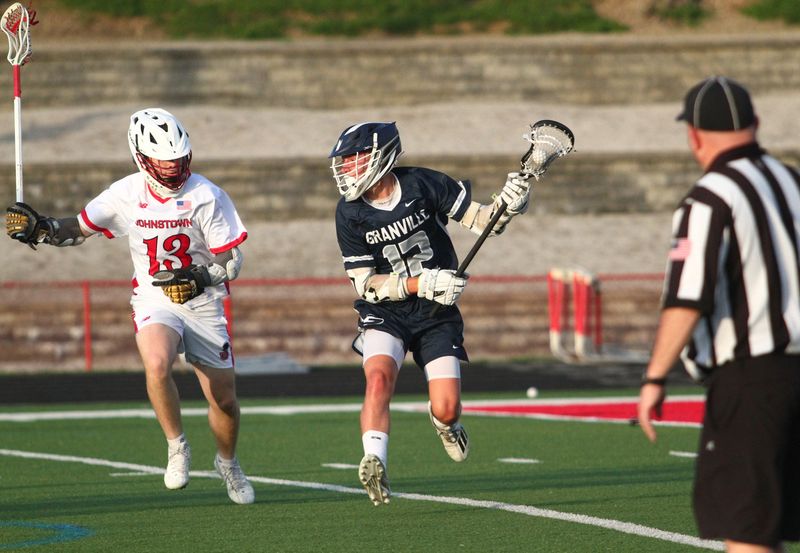 Granville's Landon Goss attempts to elude Johnstown's Zeke Severs behind the cage during the visiting Blue Aces' 10-3 victory on April 28, 2026.