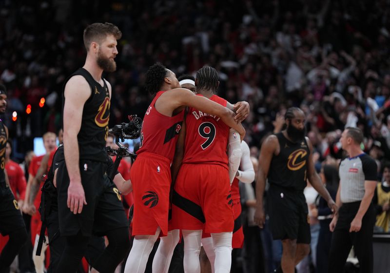 Cleveland Cavaliers forward Dean Wade, left, looks on as Toronto Raptors forward Scottie Barnes hugs forward RJ Barrett (9) after Barrett scored the winning basket against the Cavaliers in overtime in Game 6 of a first-round NBA playoff series May 1 2026, in Toronto, Ontario, Canada.