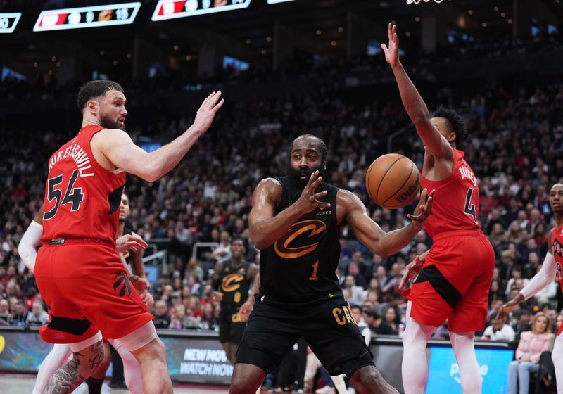 May 1, 2026; Toronto, Ontario, CAN; Cleveland Cavaliers guard James Harden (1) passes the ball between Toronto Raptors forward Scottie Barnes (4) and forward Sandro Mamukelashvili (54) during the third quarter in game six of the first round of the 2026 NBA Playoffs at Scotiabank Arena. Mandatory Credit: Nick Turchiaro-Imagn Images