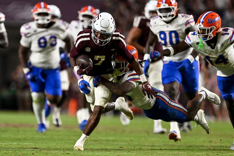 Oct 11, 2025; College Station, Texas, USA; Texas A&M Aggies wide receiver KC Concepcion (7) runs the ball as Florida Gators defensive end Titus Bullard (17) attempts the tackle during the second half at Kyle Field. Mandatory Credit: Maria Lysaker-Imagn Images
