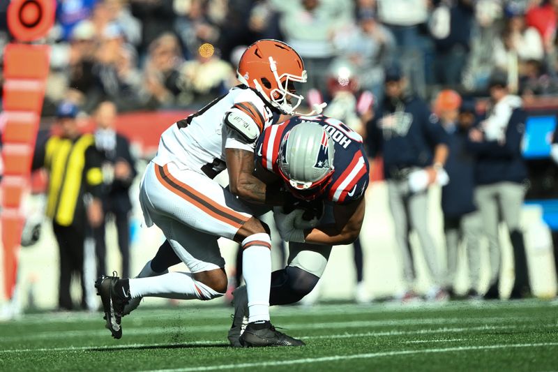 Oct 26, 2025; Foxborough, Massachusetts, USA; Cleveland Browns cornerback Denzel Ward (21) tackles New England Patriots tight end Austin Hooper (81) during the second quarter at Gillette Stadium. Mandatory Credit: Brian Fluharty-Imagn Images