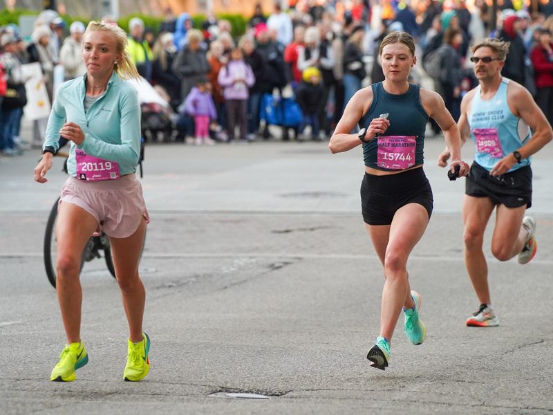 Women's half-leaders Amanda Zerhusen (20119) and Madeline Trevisan (15744) climb Vine Street at the five-mile mark of the Flying Pig Half Marathon on May 3, 2026.