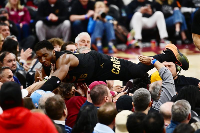 May 3, 2026; Cleveland, Ohio, USA; Cleveland Cavaliers guard Donovan Mitchell (45) dives into the crowd for a loose ball during the second half against the Toronto Raptors of game seven in the first round of the 2026 NBA Playoffs at Rocket Arena. Mandatory Credit: Ken Blaze-Imagn Images