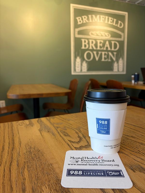 The Mental Health and Recovery Board of Portage County has placed coffee sleeves and coasters in local coffee shops, bars, and fraternal and veterans’ organizations, featuring information about the 988 Suicide & Crisis Lifeline. The Brimfield Bread Oven is one of the participating businesses.