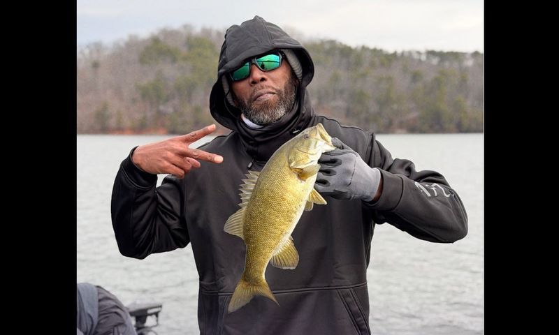 NFL Hall of Famer Randy Moss holding a bass.