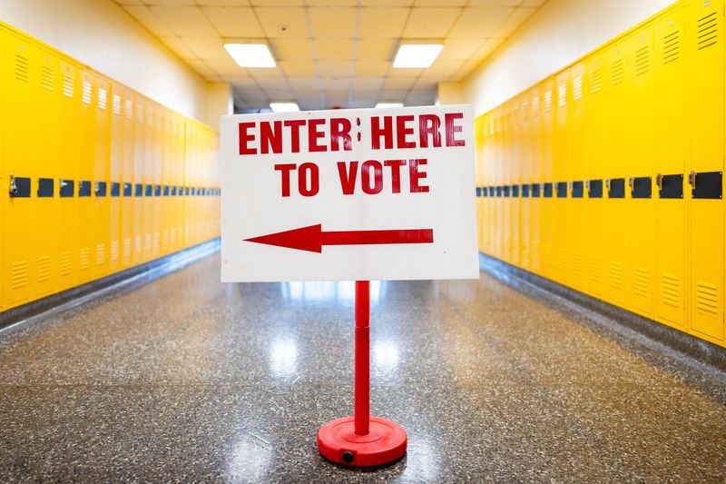 A sign guiding residents to the correct polling location room is seen in the hallway of North High School on primary voting day May 5, 2026, in Akron, Ohio.