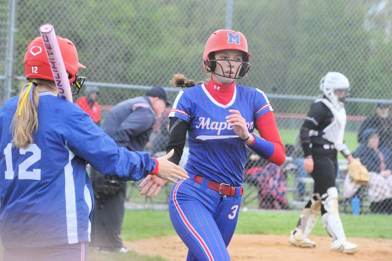 Mapleton's Payten Frye high fives Aubree Hess after scoring a run. The Mounties won 6-0 in Firelands Conference play on May 6, 2026.