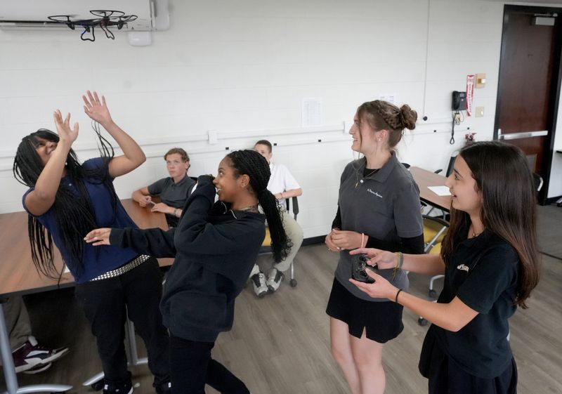 St. Thomas Aquinas students Olivia Johnson, from left, Jasmine West, Evelyn Powell and Colleen Robertson, react as a drone goes off course during class.