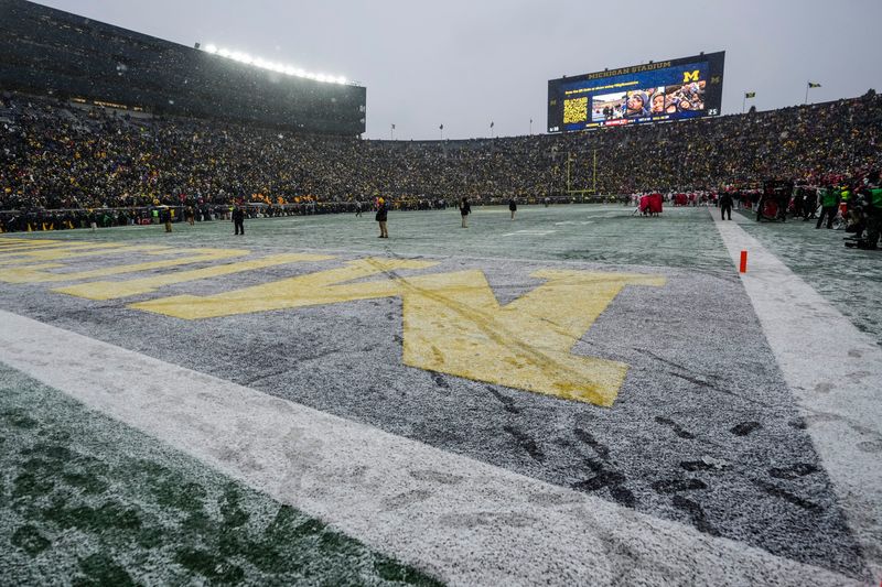 An M in the endzone is crossed out in snow by Ohio State mascot Brutus during the NCAA football game at Michigan Stadium in Ann Arbor, Mich. on Nov. 29, 2025. Ohio State won 27-9.