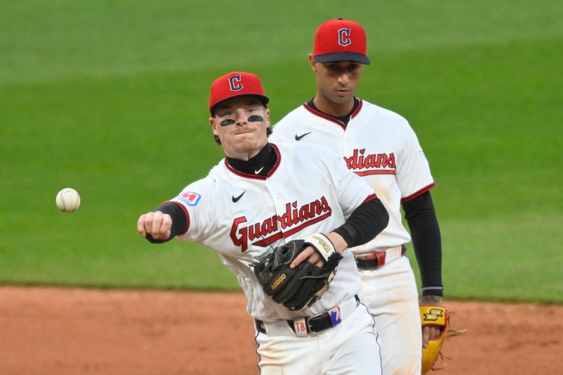 Cleveland Guardians second baseman Travis Bazzana throws to first to complete a double play as shortstop Brayan Rocchio looks on against the Los Angeles Angels on May 11, 2026, in Cleveland.