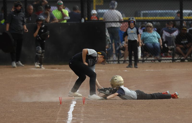 A first baseman checks the runner during a youth baseball league game at Kenney Wolford Park in this May file photo. A $450,000 donation from the IBEW will improve the facilities, safety and playing conditions for young athletes at Frew and Kenny Wolford parks.