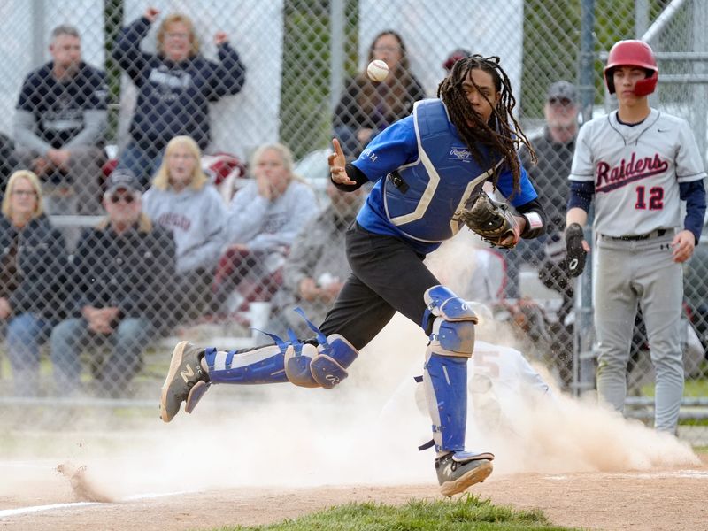 Zanesville catcher Mahki Murray snags a throw with his bare hand as Aaron Baker slides into home during a 14-13 win against host Morgan in a nonleague high school baseball game on Thursday, May 14, 2026, in McConnelsville, Ohio. The Blue Devils improved to 10-14 entering their May 15 home rematch with the Raiders at Jay Payton Field.