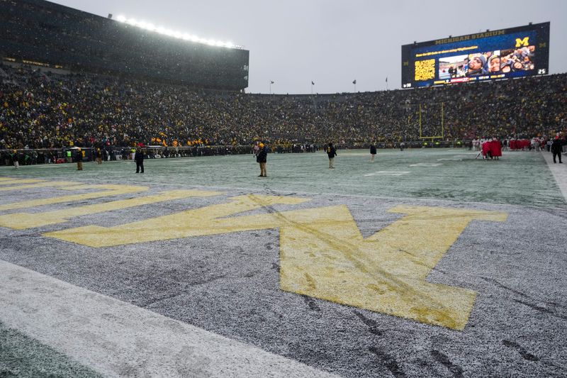 An M in the endzone is crossed out in snow by Ohio State mascot Brutus during the NCAA football game at Michigan Stadium in Ann Arbor, Mich. on Nov. 29, 2025. Ohio State won 27-9.