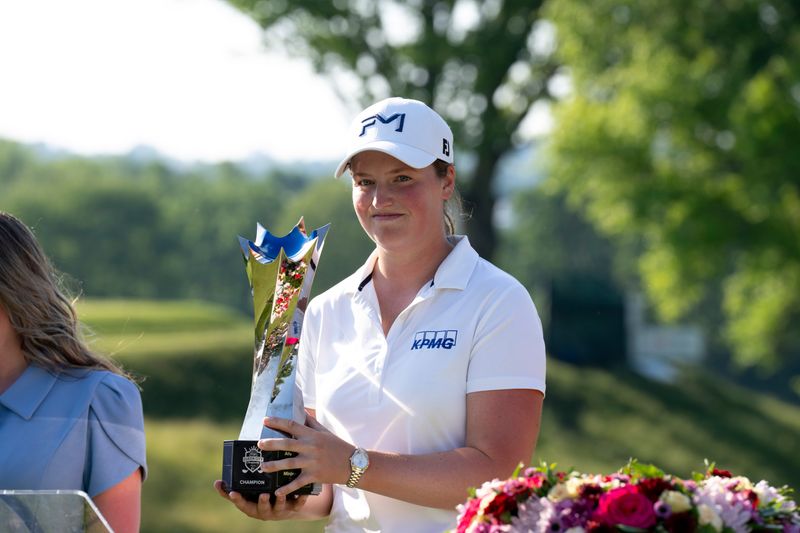 Lottie Woad, of Farnham, England, holds the trophy after winning the LPGA Kroger Queen City Championship fourth round at Maketewan Country Club in Cincinnati on Sunday, May 17, 2026.