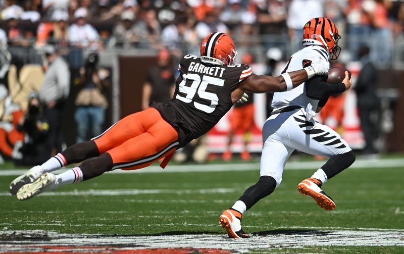 Sep 7, 2025; Cleveland, Ohio, USA; Cleveland Browns defensive end Myles Garrett (95) tackles Cincinnati Bengals quarterback Joe Burrow (9) during the first half at Huntington Bank Field. Mandatory Credit: Ken Blaze-Imagn Images