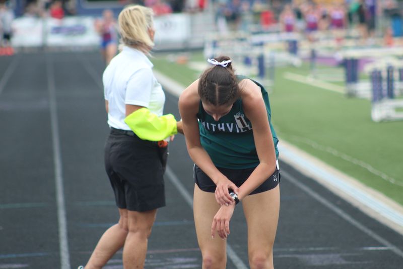 Smithville's Kaitlyn Carr checks the time on her running watch after her victory in the 1600 meters at the Triway Invitational in April.