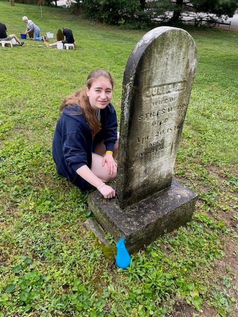 Granville citizen Olivia Power prepares to clean the marble headstone of Julia A. Webb (1810-1846), which had become darkened over the years by lichen and other growths.