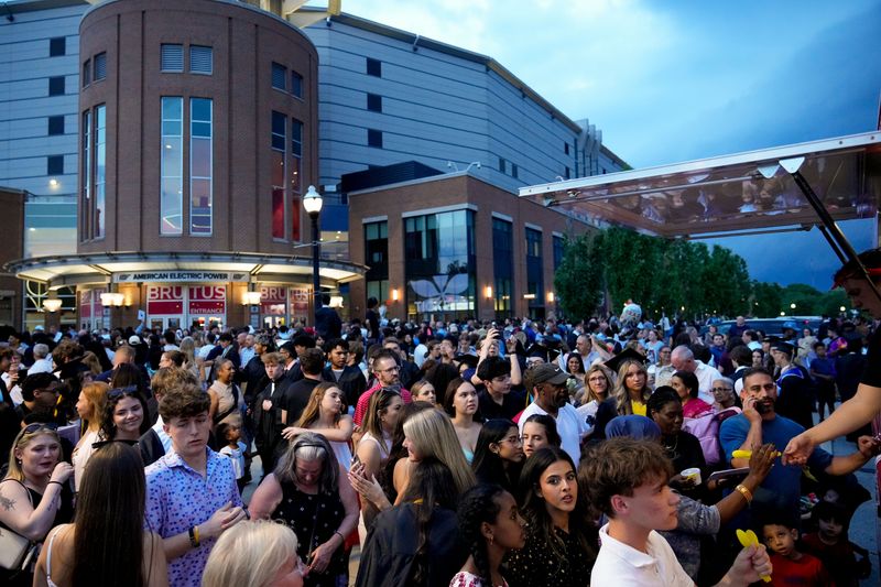 Graduates and commencement attendees receive free ice cream from Little Ladies Soft Serve courtesy of Bruno Mars outside the Schottenstein Center on Tuesday, May 19, 2026 in Columbus, Ohio.