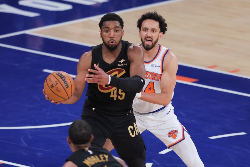 Cavaliers guard Donovan Mitchell passes to forward Evan Mobley while defended by New York Knicks guard Landry Shamet during the fourth quarter of Game 1 of the Eastern Conference Finals at Madison Square Garden, May 19, 2026.