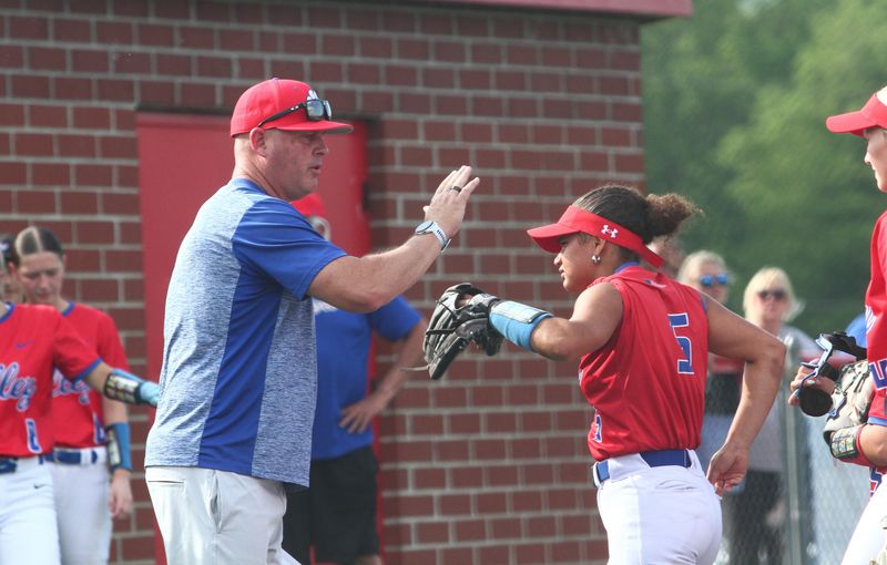 Licking Valley coach Chad Dennis congratulates his team, including daughter D'Neya (5), following a clean inning during the Panthers' 11-0 victory against visiting Heath in a Division IV district semifinal on May 19, 2026.