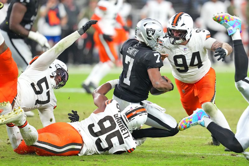 Nov 23, 2025; Paradise, Nevada, USA; Las Vegas Raiders quarterback Geno Smith (7) is sacked by Cleveland Browns defensive end Myles Garrett (95) as defensive tackle Mason Graham (94) looks make a tackle on the play during the fourth quarter at Allegiant Stadium. Mandatory Credit: Stephen R. Sylvanie-Imagn Images