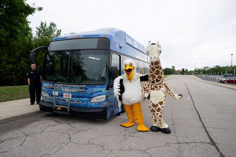Zoo mascots pose next to the COTA Zoo Bus. Daily service begins May 23.