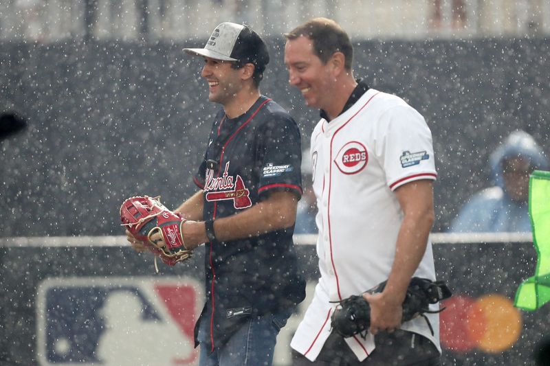 NASCAR series drivers Chase Elliot (left) and Kyle Busch head onto the field for a ceremonial first pitch prior to the Speedway Classic game between the Cincinnati Reds and the Atlanta Braves at Bristol Motor Speedway.