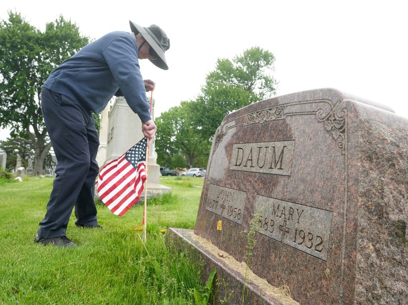 Mike Molnar, a parishioner at Basilica of St. John the Baptist and St. Peter Parish, puts out flags for Memorial Day at St. Peter's cemetery in Canton.