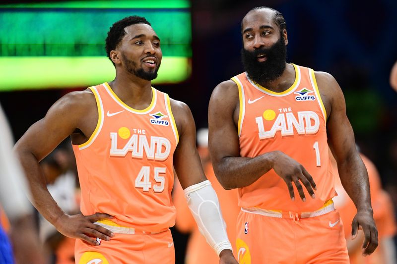 Cavaliers guards Donovan Mitchell (45) and James Harden talk during a break in the second half against the Orlando Magic, March 24, 2026, in Cleveland.