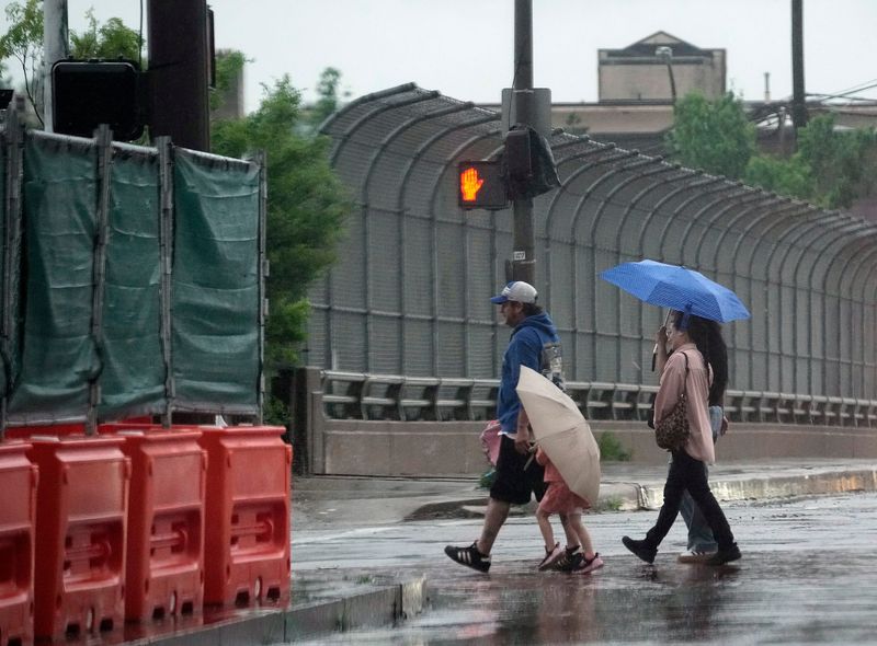 Multiple rounds of rain and storms are expected Wednesday, May 27 after a rainy Memorial Day weekend, posing flooding risks for Central Ohio. Rain comes down as a pedestrian walk across South High Street in Columbus.