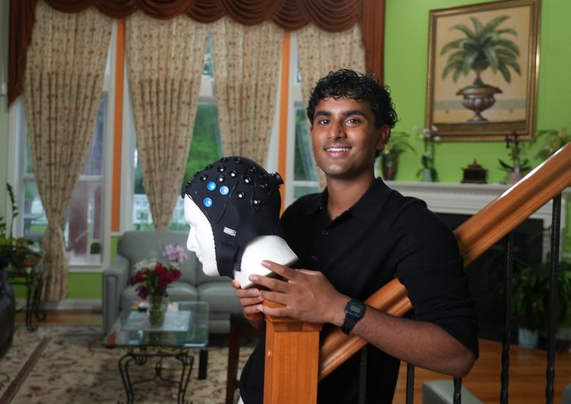 Olentangy Orange High School graduate Nikhil Bhimireddy, pictured here May 27 in his family's Lewis Center home, developed a new kind of functional near-infrared spectroscopy cap. He got the idea after trying on a similar cap during an internship at Nationwide Children’s Hospital. He found that didn't work so well with people with darker skin and certain hair textures, so he created a prototype of a new cap that he says solves those problems.
