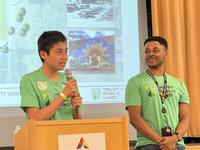 Jennings Community Learning Center seventh grader Santiago De Leon Flores talks to the audience with his teacher Zion Johnston on May 27.