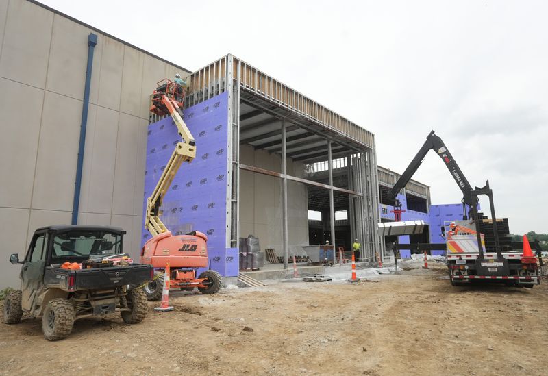 Workers construct what will be the entrance of the Gameday Bay waterpark at the Hall of Fame Village. Work on the project is now about 65% complete.