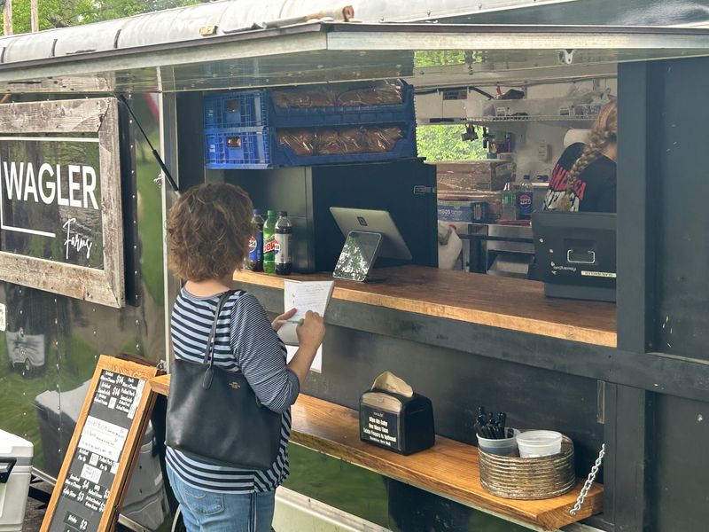 Beacon Journal restaurant writer Kerry Clawson checks out options at the Wagler Farms food truck May 24 at the Highland Square Food Truck Fest.