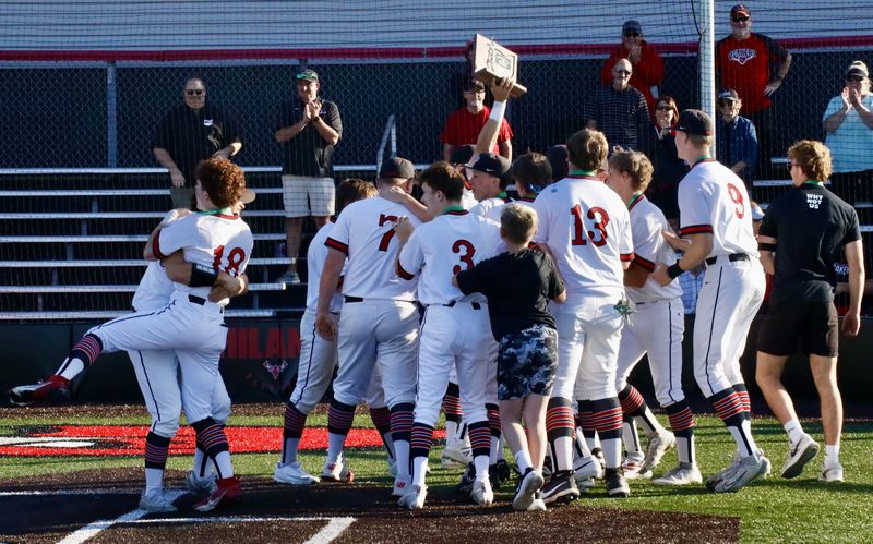 New Philadelphia players celebrate with Division III East District Championship trophy after defeating Tri-Valley 3-2 on May 28, 2026.