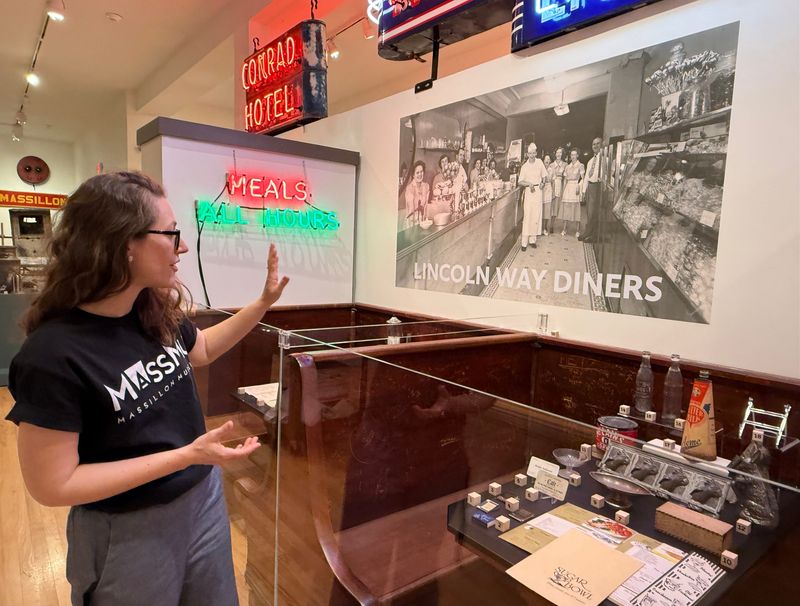 Valerie Metzger, curator of art and artifacts at Massillon Museum, discusses a diner display that's part of the new Lincoln Highway exhibition, which is open through Oct. 18.