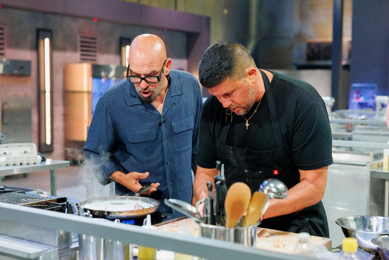 Host Michael Symon interacts with contestant Joe Isidori, Arthur & Sons' chef-proprietor, as seen on 24 in 24: Last Chef Standing, season 3.